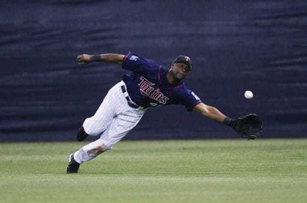 Torii Hunter #48 of the Minnesota Twins tries to reach a ball hit by Mark Kotsay of the Oakland Athletics in the 7th inning of game two of the American League Division Series at the Hubert H. Humphrey Metrodome on October 04, 2006 in Minneapolis, Minnesota.The Athletics defeated the Twins 5-2.