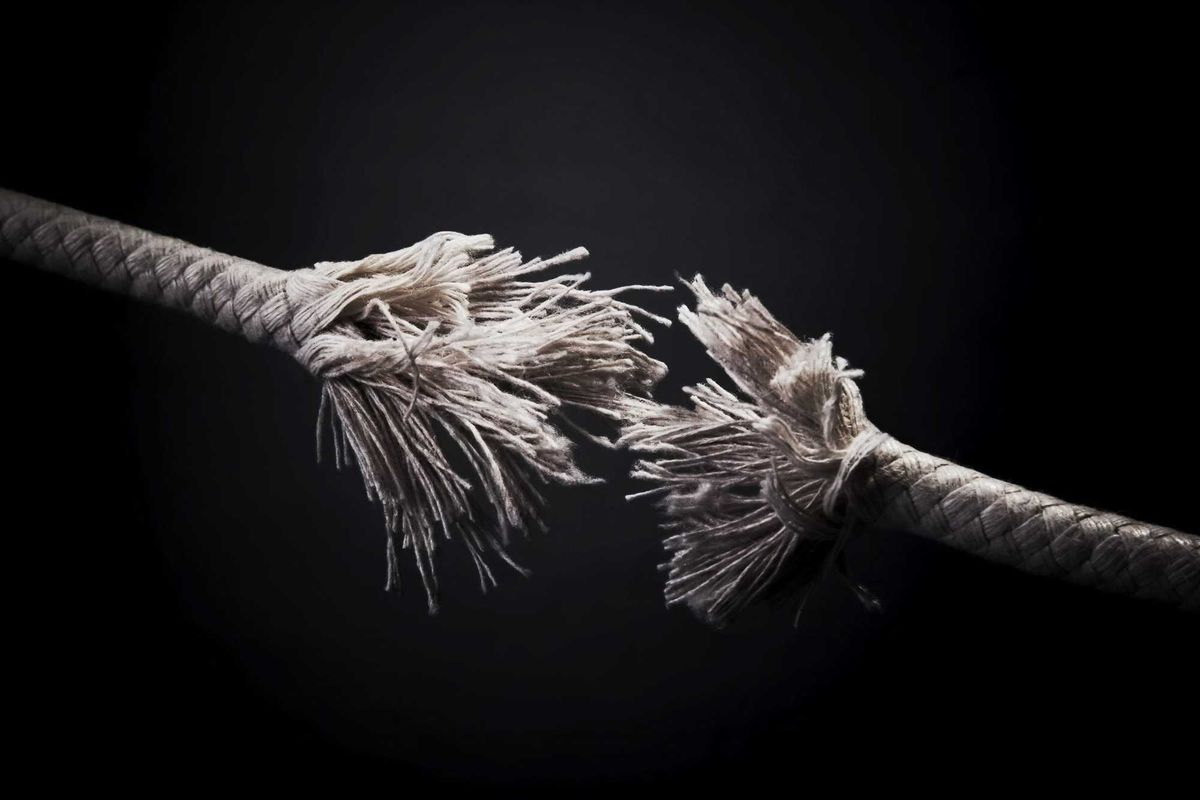 Torn rope against black background.