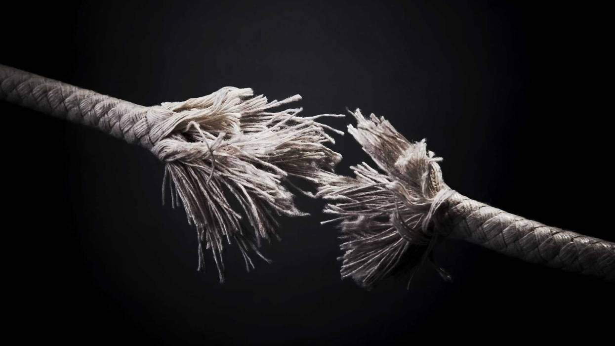 Torn rope against black background.