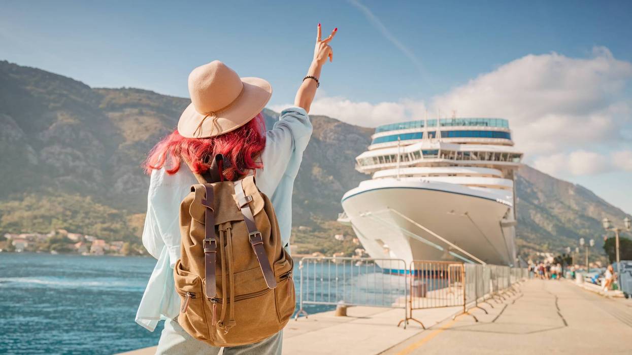 Tourist gesturing near cruise ship at Kotor bay, Montenegro