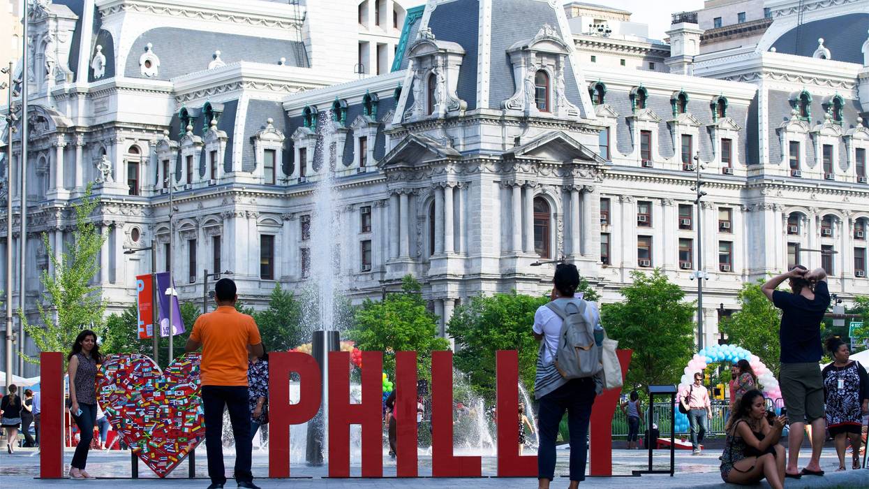 Tourists and locals take pictures at a large "I Love Philly" sign at LOVE Park in Center City Philadelphia in the summer of 2019.