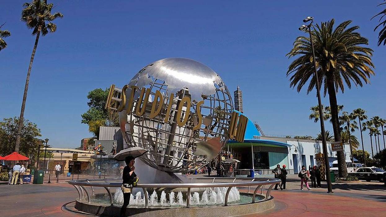 Tourists get their picture taken at the front entrance of Universal Studios Hollywood theme park on May 4, 2010 in Universal City, California.