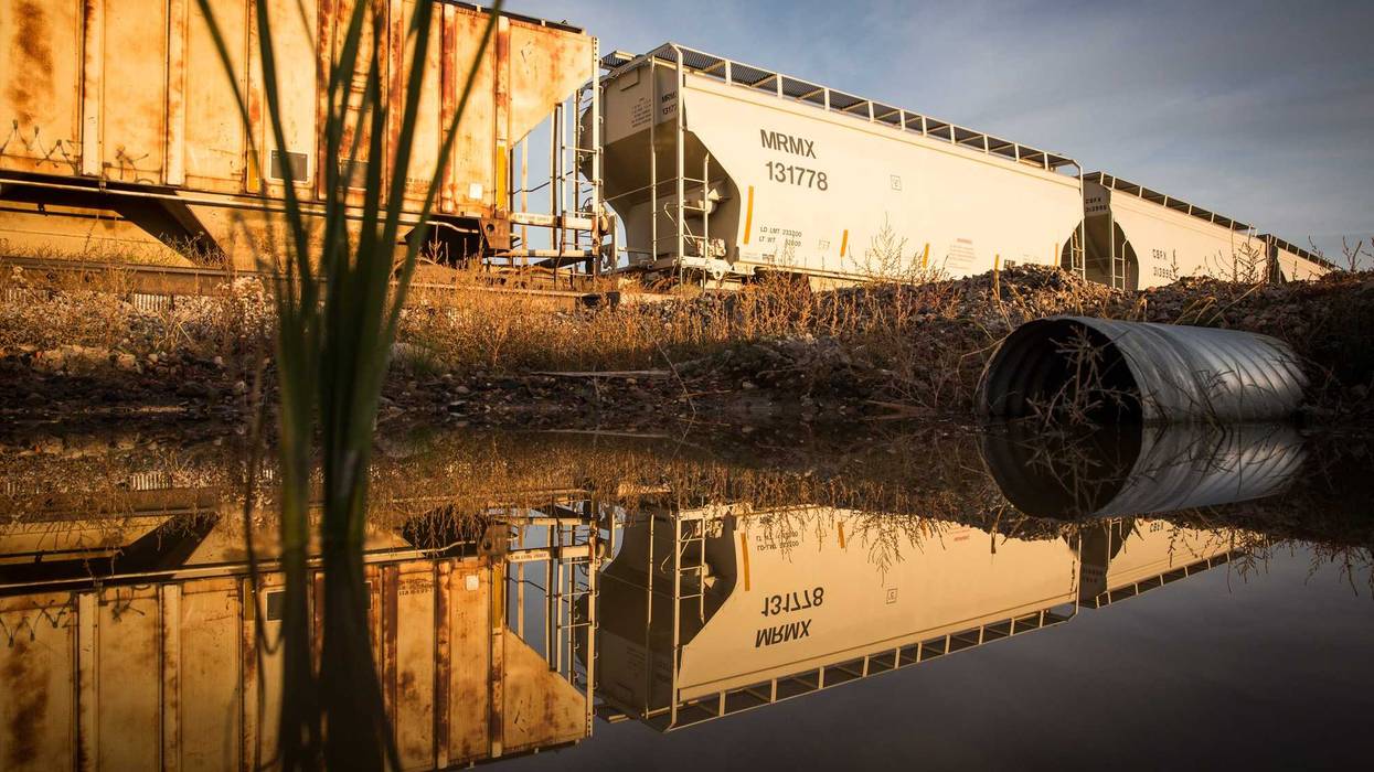 Train cars sit next to miles of unused pipe (unseen), prepared for the proposed Keystone XL pipeline, on October 14, 2014 outside Gascoyne, North Dakota.