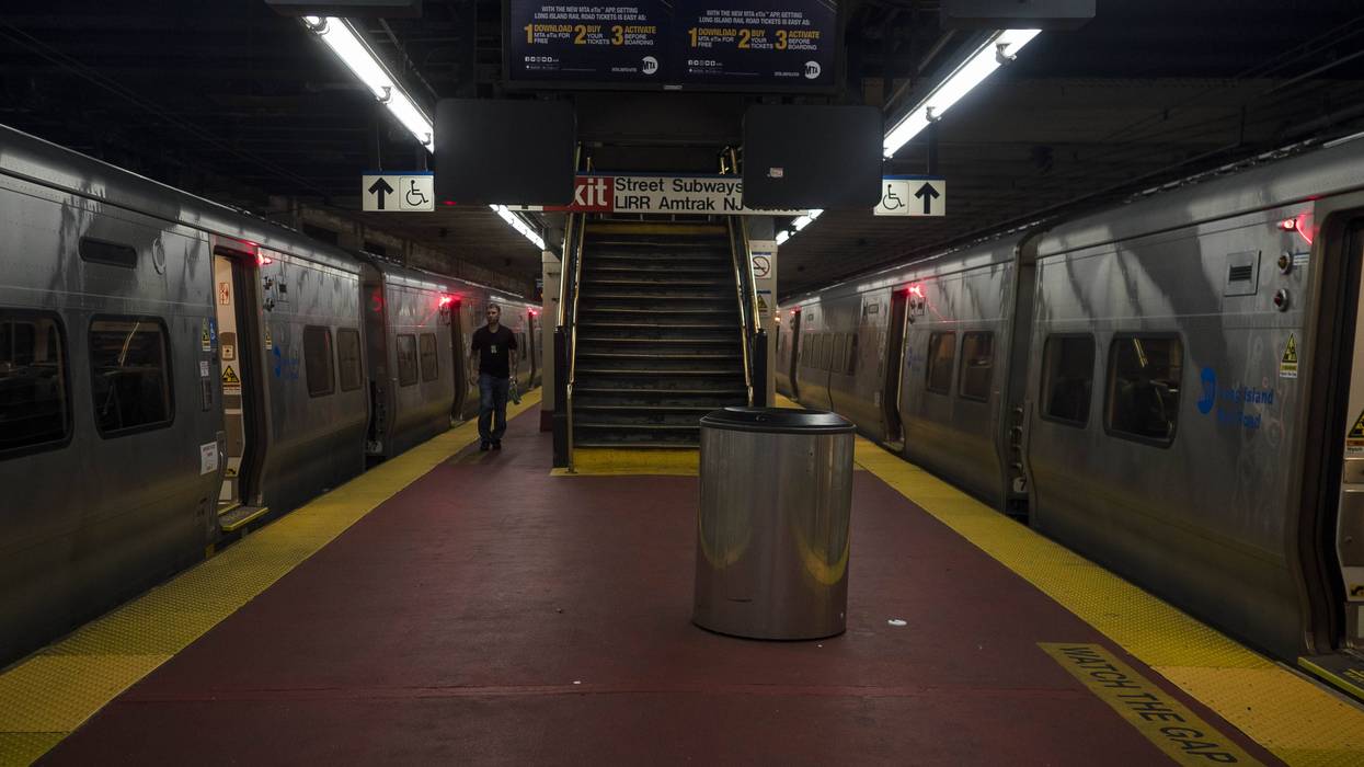 Trains on a platform inside Penn Station in New York City.