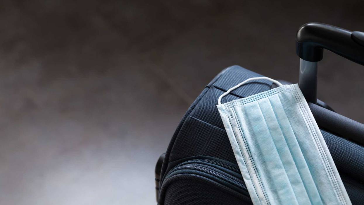 Travel suitcase and medical mask. The ban on travel during the epidemic of coronavirus and quarantine against corona virus or covid-19 concept.
