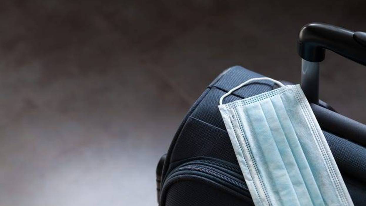 Travel suitcase and medical mask.
