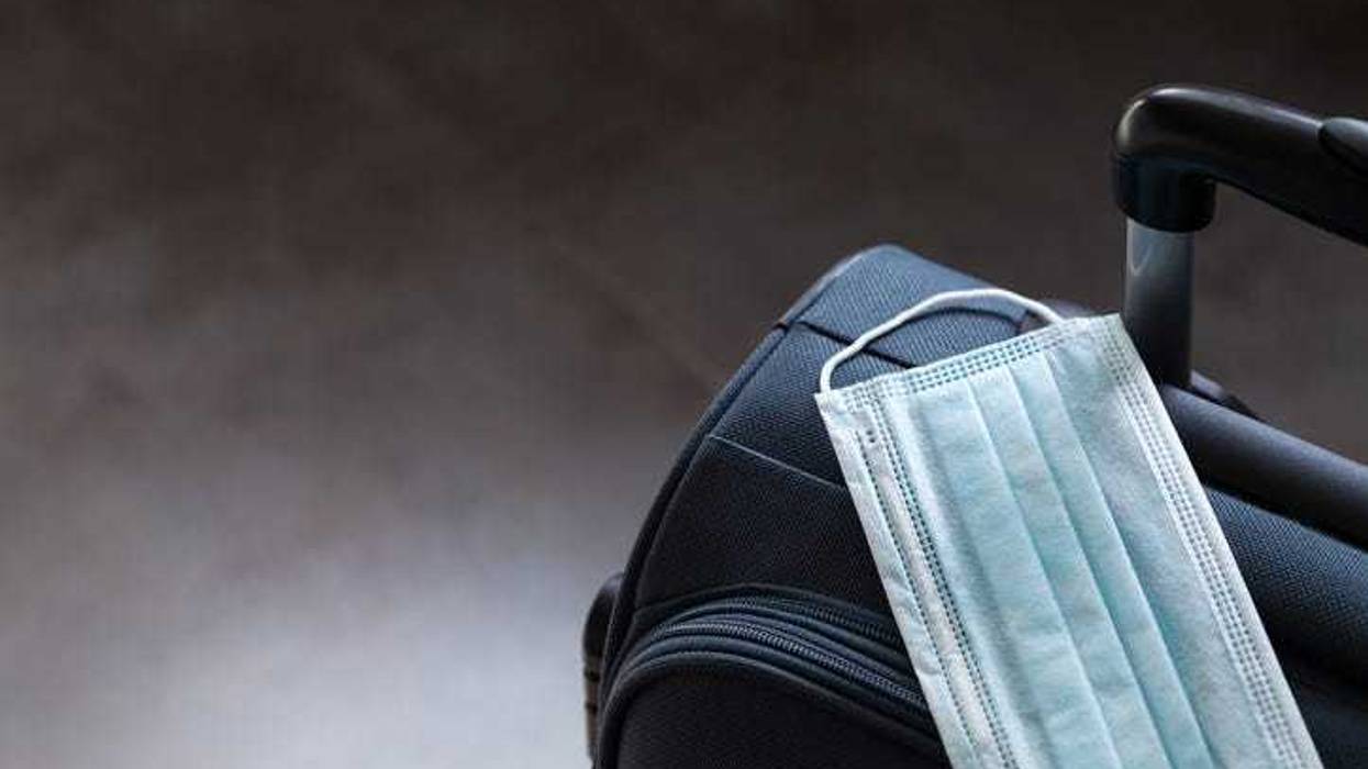 Travel suitcase with a mask on it.