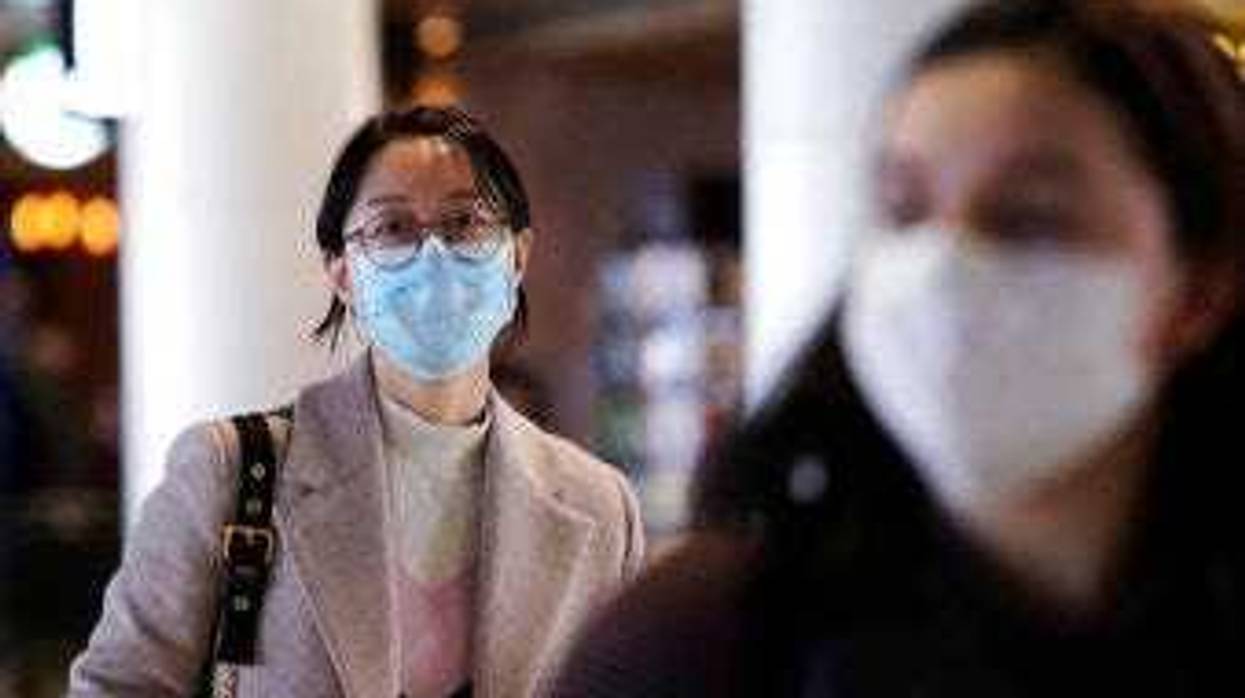 Travelers at Seattle-Tacoma International Airport wear masks Tuesday, March 3, 2020, in SeaTac, Wash. (AP Photo/Elaine Thompson)