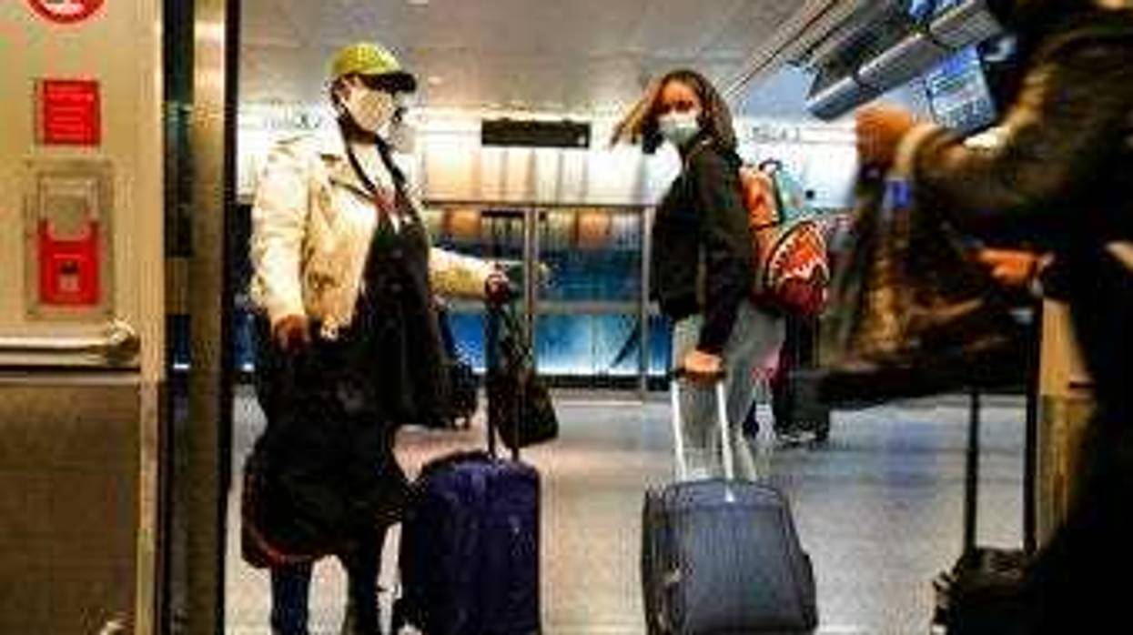 Travelers leave the AirTrain at JFK International Airport Friday, Nov. 20, 2020, in New York. (AP Photo/Frank Franklin II)