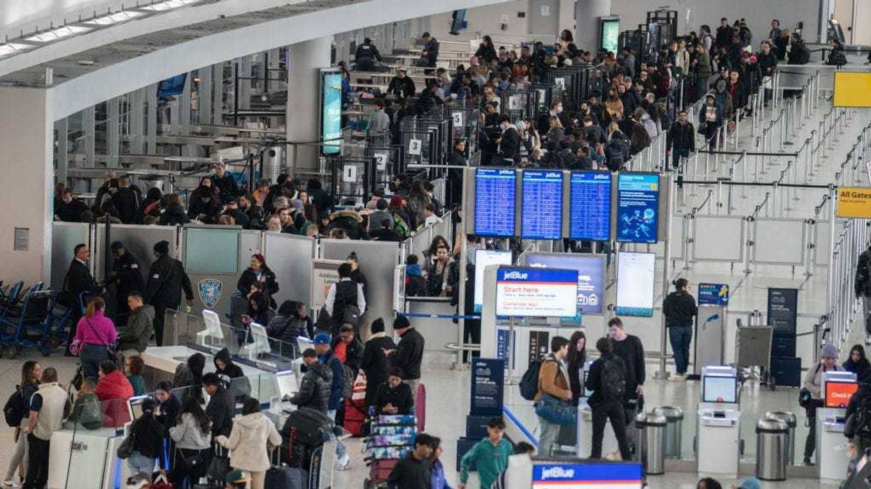 Travelers line up to enter a security checkpoint at John F. Kennedy International Airport (JFK) on December 23, 2023 in New York, New York.