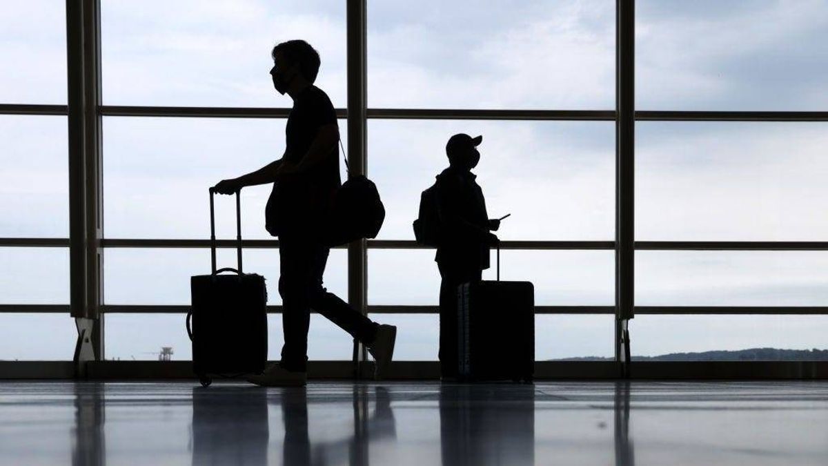 Travelers pass through the concourse at Ronald Reagan Washington National Airport on the eve of Memorial Day long weekend May 28, 2021 in Arlington, Virginia.