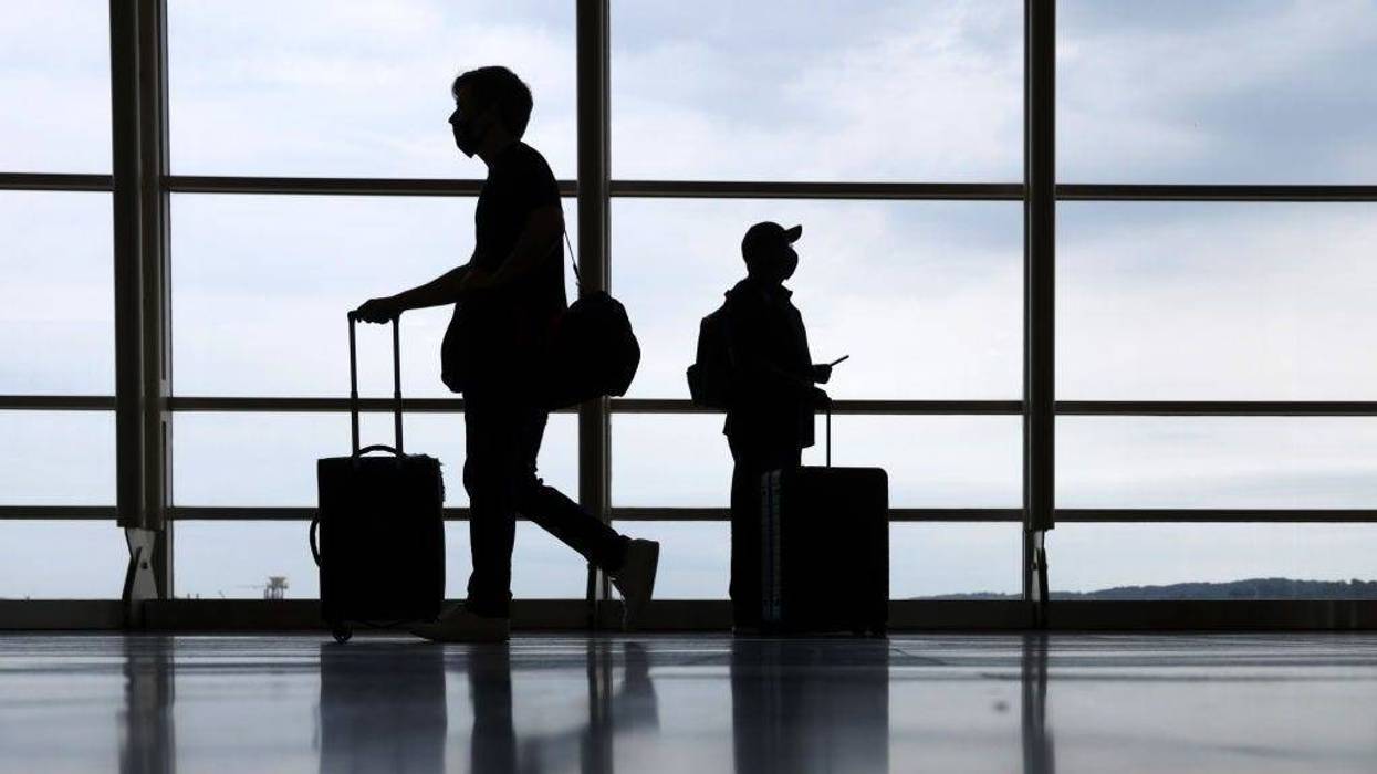 Travelers pass through the concourse at Ronald Reagan Washington National Airport on the eve of Memorial Day long weekend May 28, 2021 in Arlington, Virginia.