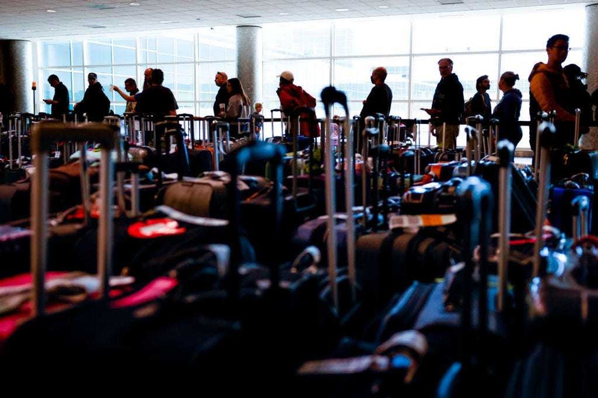 Travelers wait in line before they are allowed to search for their luggage in a baggage holding area for Southwest Airlines at Denver International Airport on December 28, 2022 in Denver, Colorado.