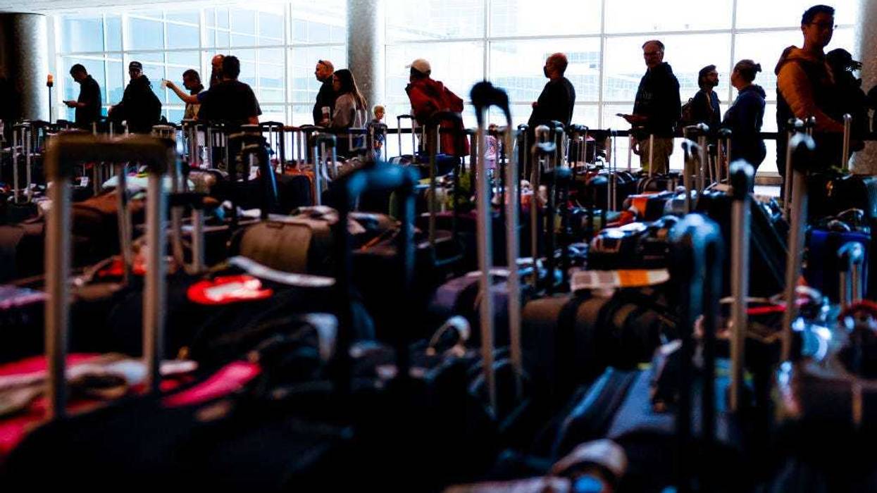 Travelers wait in line before they are allowed to search for their luggage in a baggage holding area for Southwest Airlines at Denver International Airport on December 28, 2022 in Denver, Colorado.