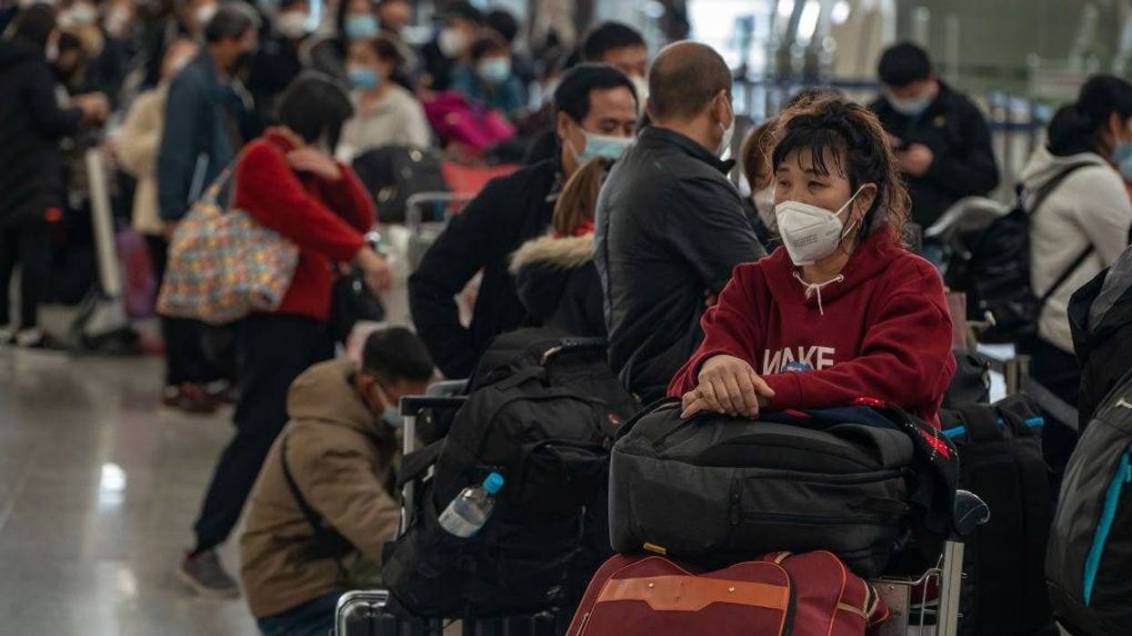 Travelers wait in line to check in at the departure hall of the Hong Kong International Airport on December 30, 2022 in Hong Kong, China.