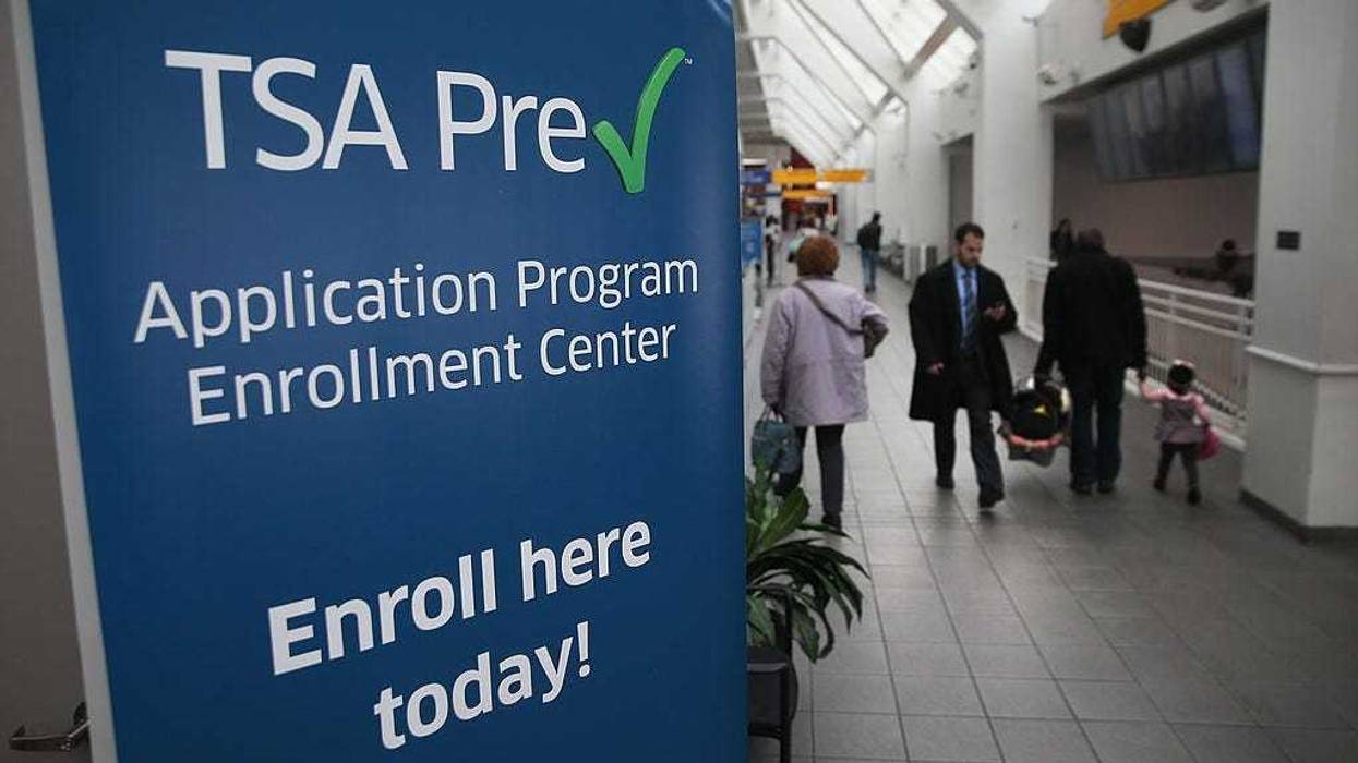 Travelers walk past a newly-opened TSA Pre-check application center at Terminal C of the LaGuardia Airport on January 27, 2014 in New York City. Once approved, travelers can use special expidited Precheck security lanes. They can also leave on their shoes, light outerwear and belt, as well as keep their laptop and small containers of liquids inside carry-on luggage during security screening. The TSA plans to open more than 300 application centers across the country.