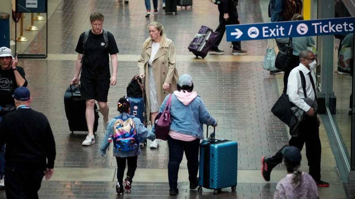 Travelers with luggage walk along the concourse on their way to board an Amtrak train at Union Station on May 27, 2022 in Washington, DC.