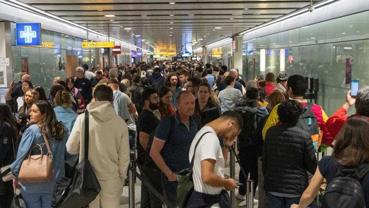 Travellers wait in a long queue to pass through the security check at Heathrow on June 1, 2022 in London, England.