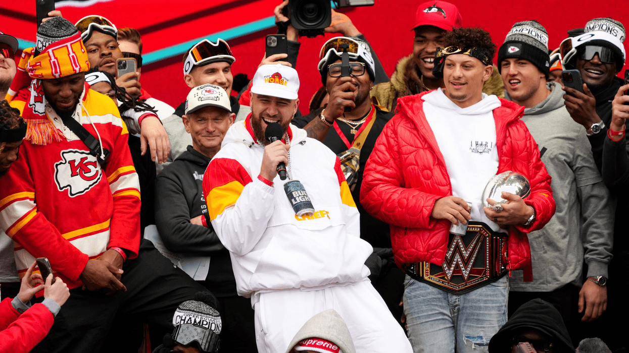 Travis Kelce, center, and Patrick Mahomes of the Kansas City Chiefs celebrate on stage with teammates during their Super Bowl LVII victory parade on Feb. 15, 2023 in Kansas City, Missouri.
