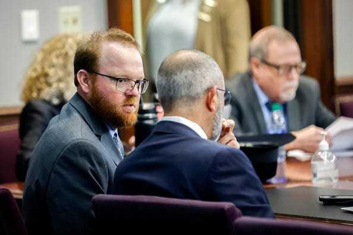 Travis McMichael, left, speaks with his attorney Jason B. Sheffield