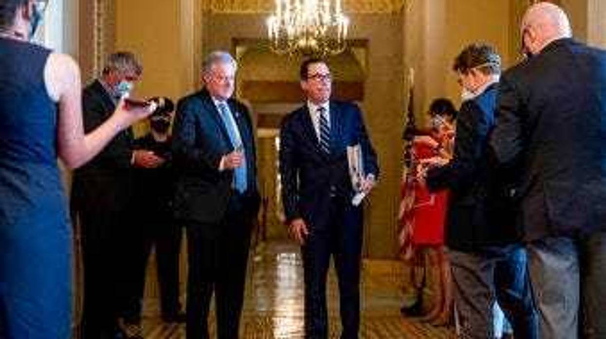 Treasury Secretary Steven Mnuchin, right, accompanied by White House chief of staff Mark Meadows, left, take a question from a reporter following a meeting with Senate Majority Leader Mitch McConnell of Ky. (AP Photo/Andrew Harnik)