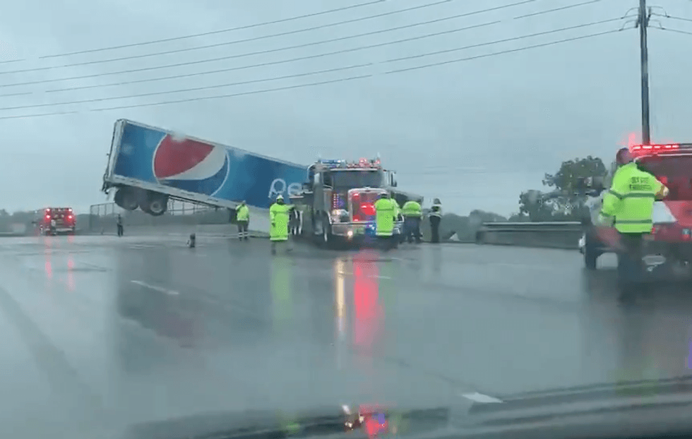 PHOTOS: Tractor-trailer driver rescued hanging off highway
