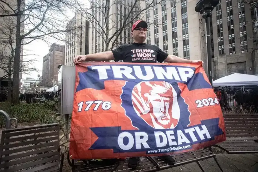 Trump supporter Dion Cini of Brooklyn holds a sign across the street from the Manhattan Criminal Courthouse April 4, 2023, before the arraignment of the former president.