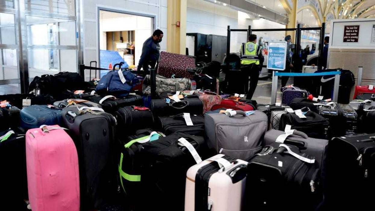 TSA agents sort through luggage in the departure terminal at the Ronald Reagan Washington National Airport on December 27, 2021 in Arlington, Virginia.