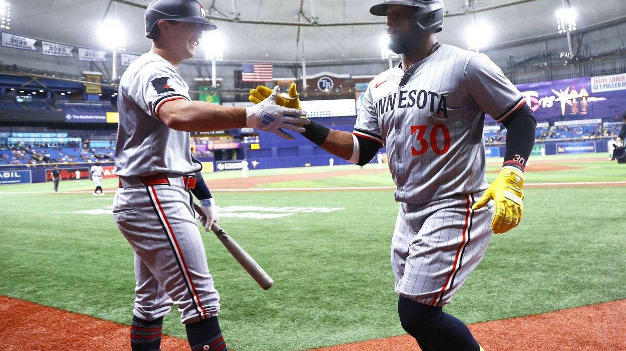 Twins first base Carlos Santana (30) is congratulated by infielder Brooks Lee (72) after hitting a home run against the Tampa Bay Rays during the second inning at Tropicana Field.
