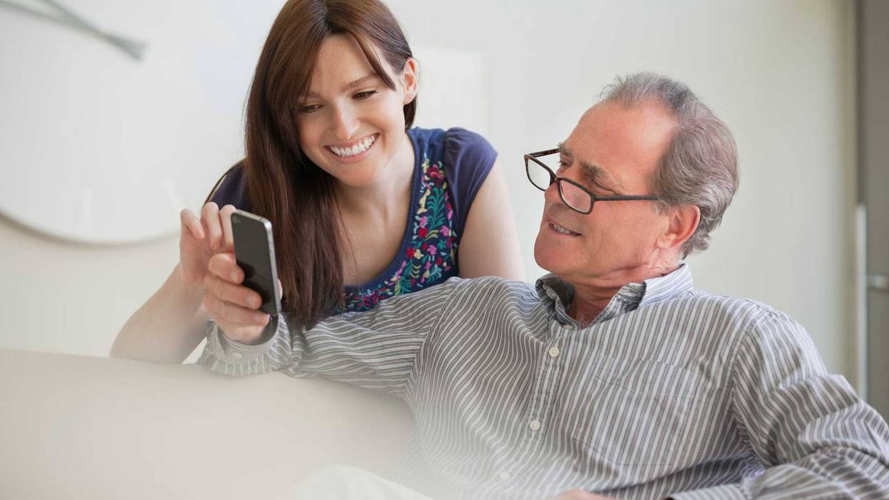 Two adults looking at social media on a phone.