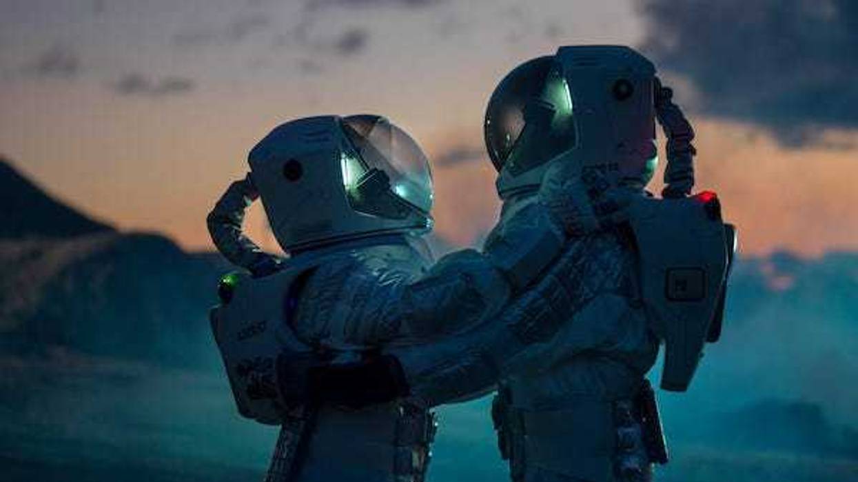 Two astronauts hugging in space suits