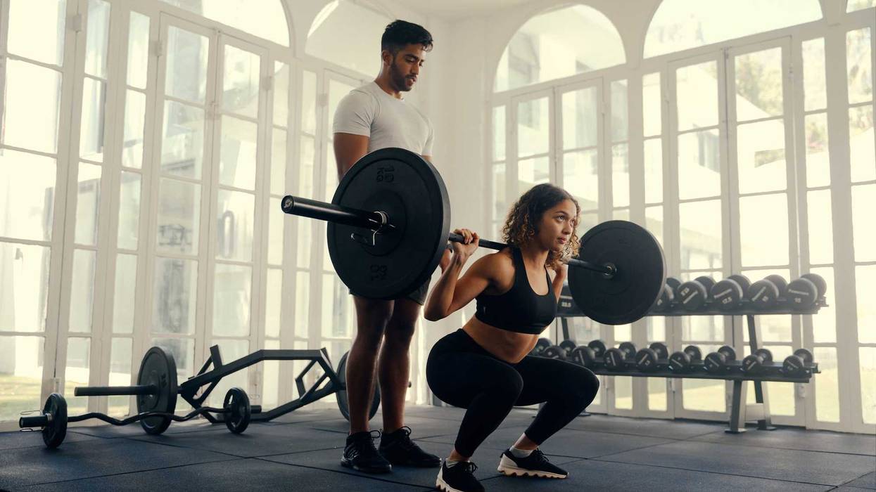 Two fit young adults in sports clothing doing weight training at the gym