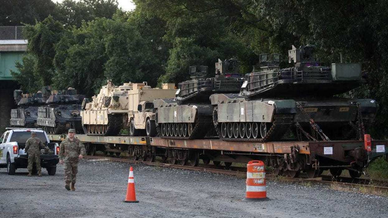 Two M1A1 Abrams tanks and other military vehicles sit on guarded rail cars at a rail yard on July 2, 2019 in Washington, DC.