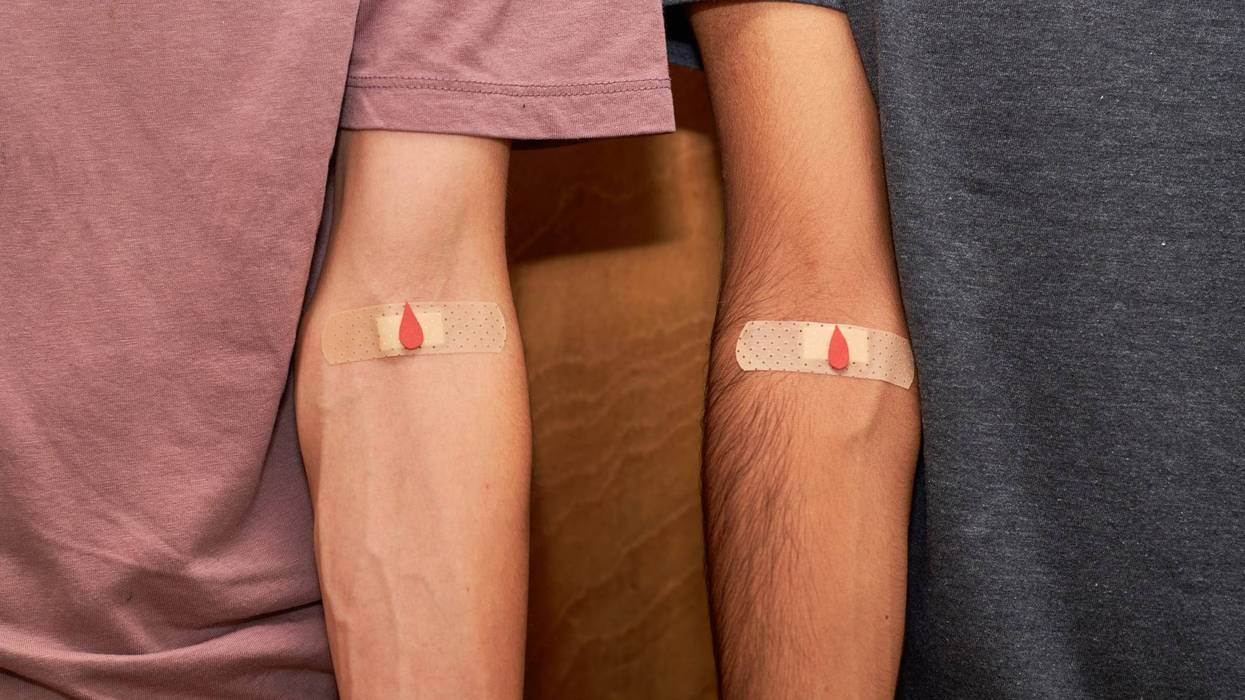 two men with bandaids on their arms after blood donation