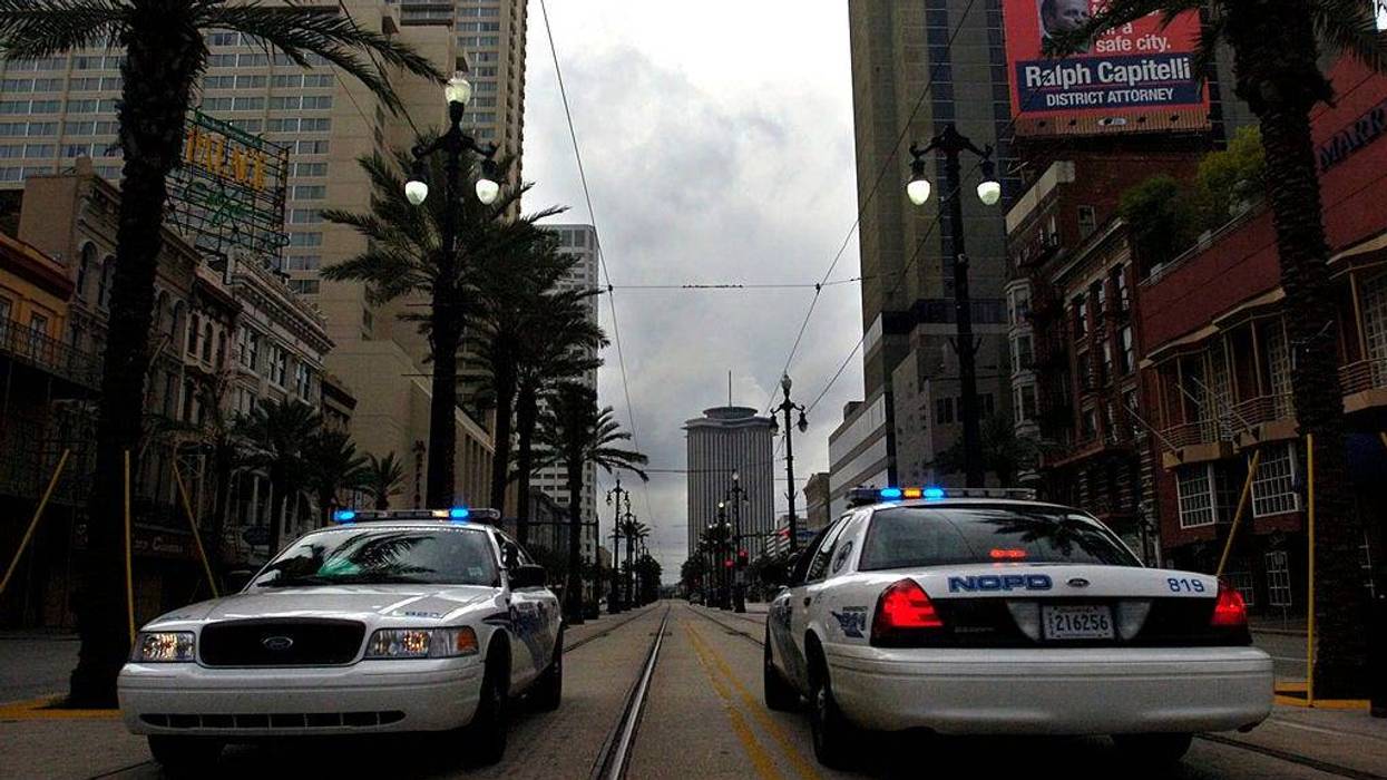 Two New Orleans police cars facing opposites ways in median of street
