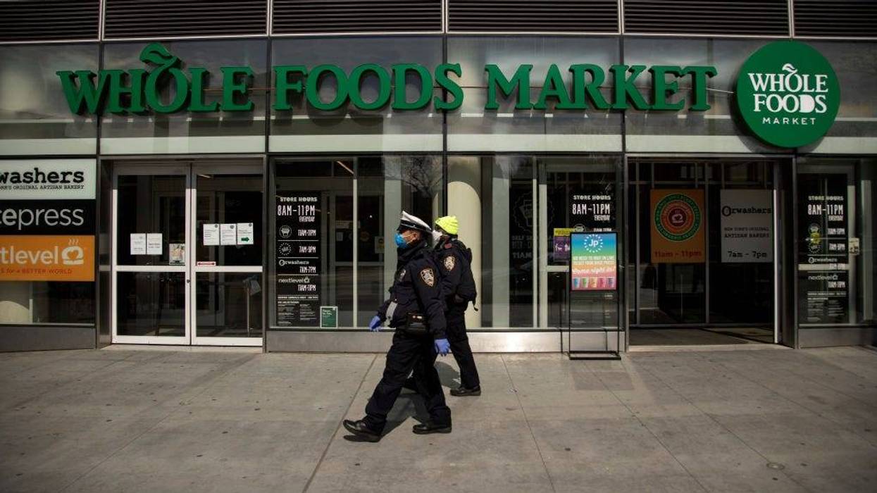 Two New York City Police Department Traffic Enforcement agents walk past the Whole Foods Market on April 14, 2020 in the Brooklyn borough of New York City.