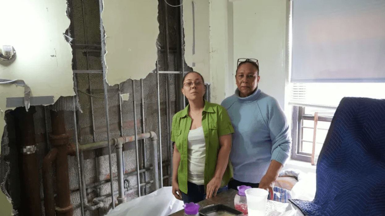 Two NYCHA residents stand in front of a destroyed wall in their apartment during a visit from Councilmember Carlina Rivera. The Public Advocate's office described NYCHA as the "overall worst landlord in New York City" in the 100 worst landlords list of 2022 list.