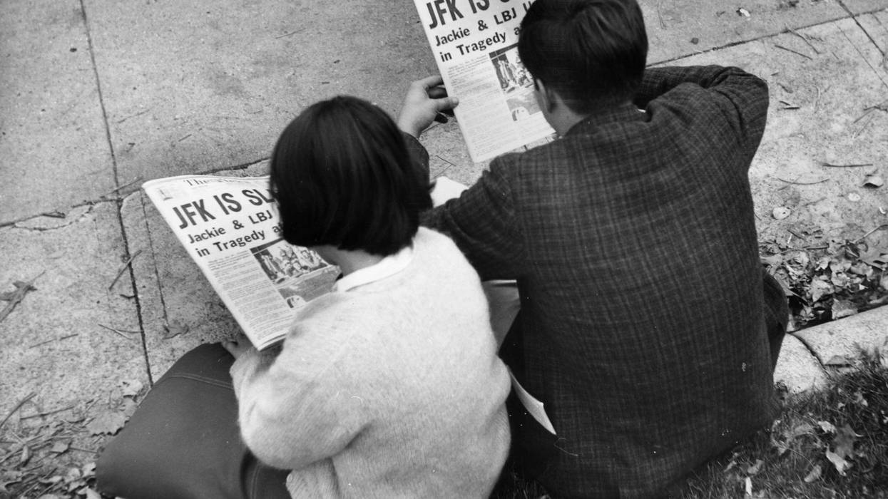 Two people in Lafayette Park, Washington, reading the newspaper reports of President John F Kennedy's assassination.