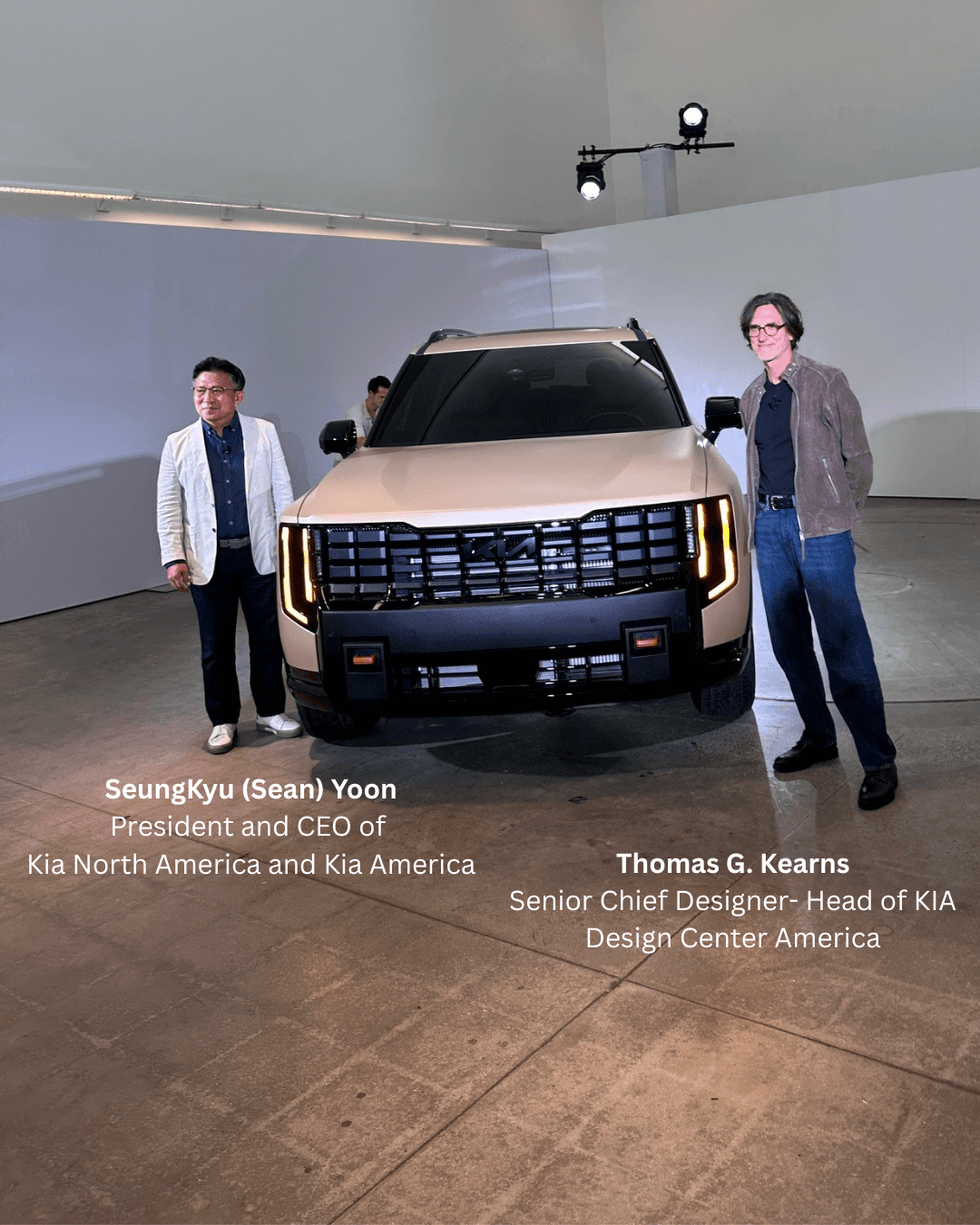 Two people stand beside a modern beige SUV in a spacious, well-lit showroom. The vehicle