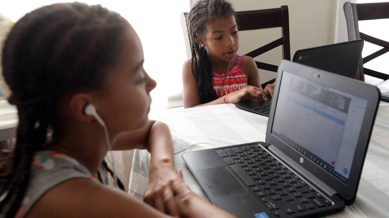Two siblings attend virtual classes.