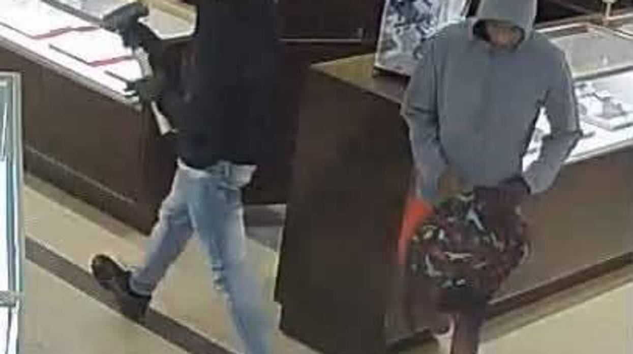 Two suspects in a jewelry store: one with a hammer, one in a grey hoodie carrying a backpack.