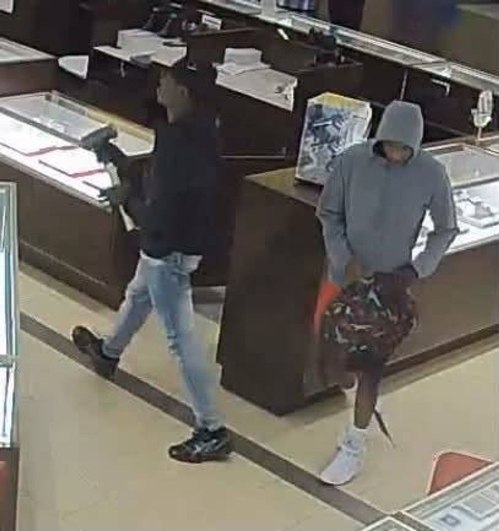 Two suspects in a jewelry store: one with a hammer, one in a grey hoodie carrying a backpack.
