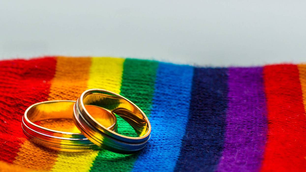 two wedding rings on a rainbow background