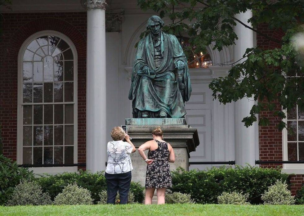Two women take pictures in front of the statue of US Supreme Court Chief Justice Roger Brooke Taney that sits in front of the Maryland State House, on August 16, 2017 in Annapolis, Maryland. Maryland Governor Larry Hogan has called for the removal of the statue. Taney was the author of the Dred Scott decision. (Photo by Mark Wilson/Getty Images)