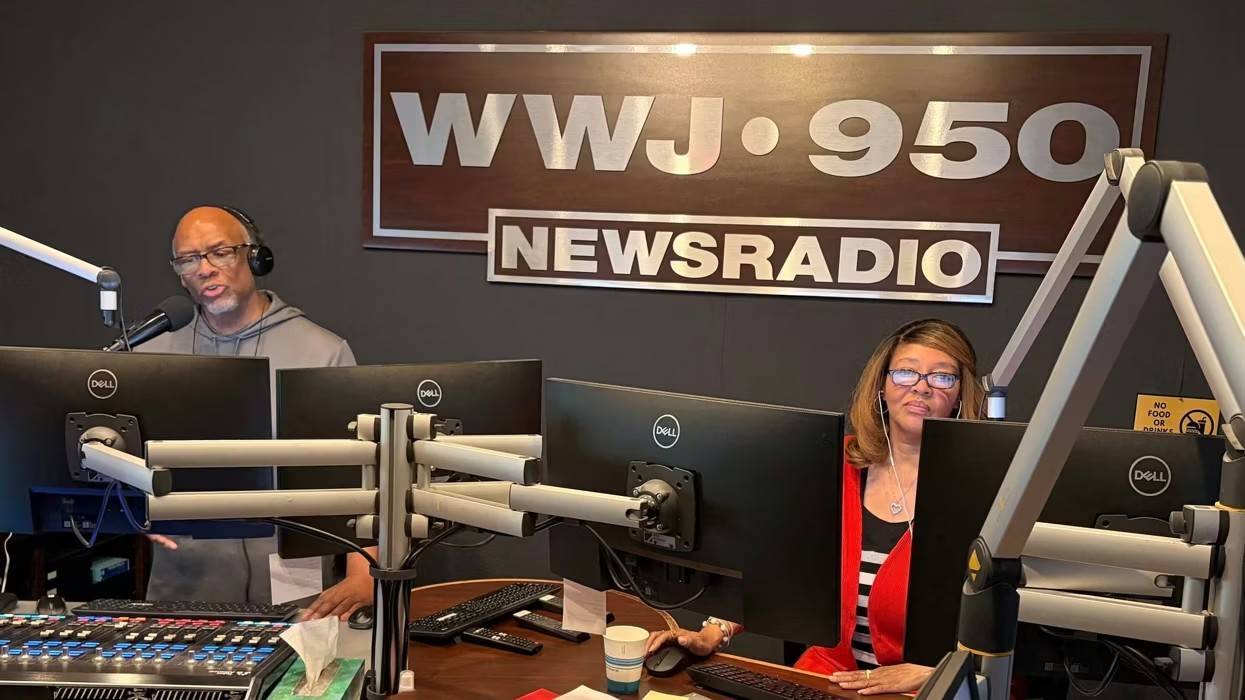Two WWJ 950 Newsradio hosts in studio, with mics, headphones & monitors.