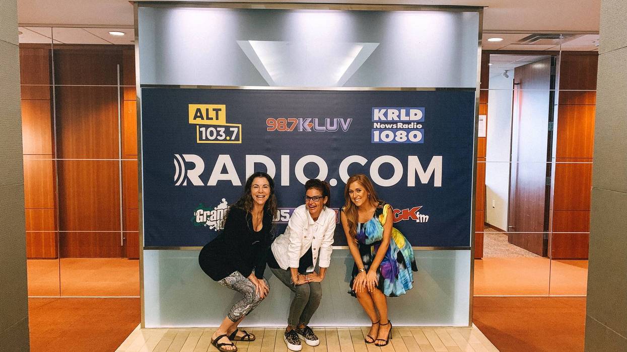 Tyler Dawn, Sybil Summers, and Hilary Kennedy pose in front of RADIO.COM sign