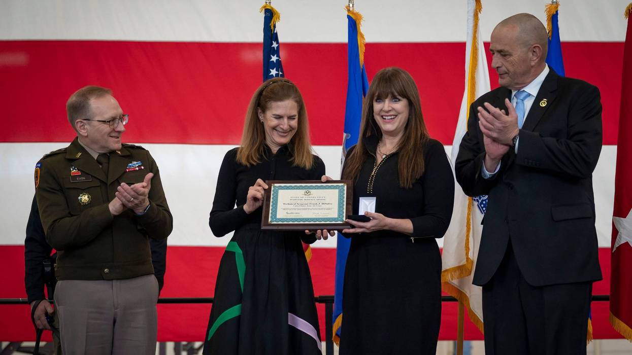 U.S. Army Maj. Gen. Francis Evon, adjutant general for the Connecticut National Guard, Connecticut Lt. Gov. Susan Bysiewicz, and U.S. Army Command Sgt. Maj. (ret.) John Carragher, the manager of veterans advocacy and assistance for the Connecticut Department of Veterans Affairs, present the Connecticut Wartime Service Medal to Renee DiNino, granddaughter of Tech. Sgt. Frank DiSalvo during a ceremony at Bradley Air National Guard Base, East Granby, Conn. Feb. 28, 2025