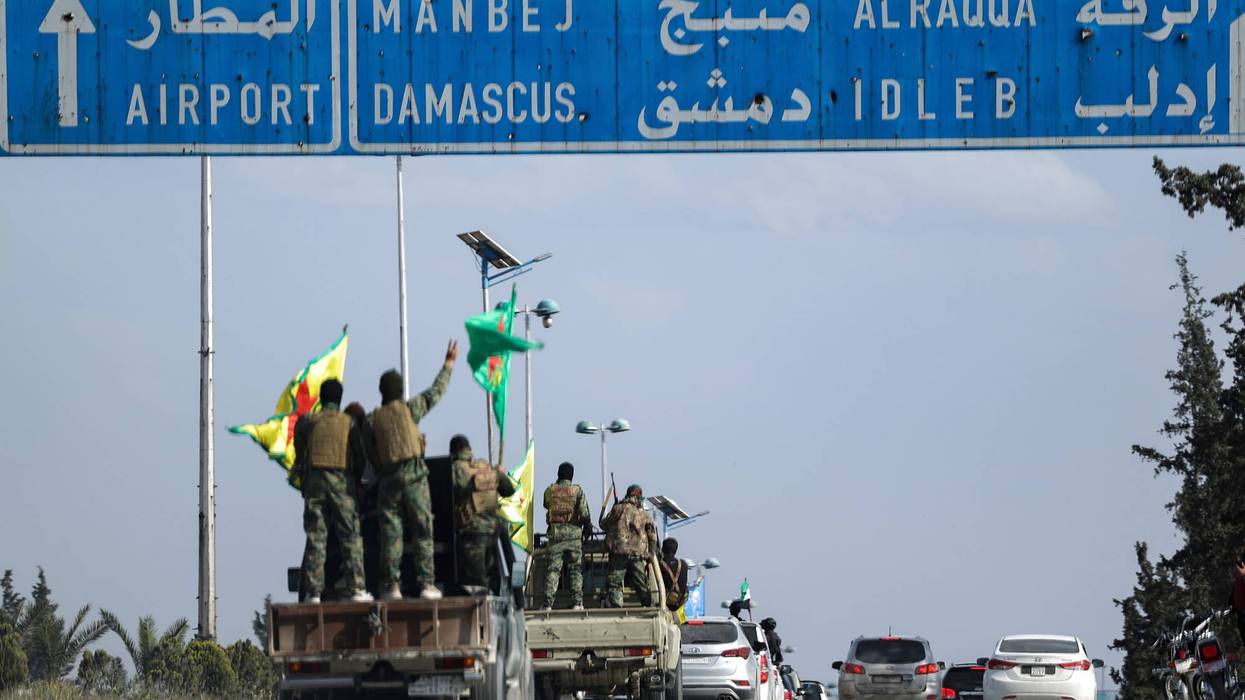 U.S.-backed Kurdish fighters stands on their vehicles, as they withdraw from two neighbourhoods in Syria's northern city of Aleppo as part of a deal with the Syrian central government, in Aleppo, Syria, Friday, April 4, 2025.