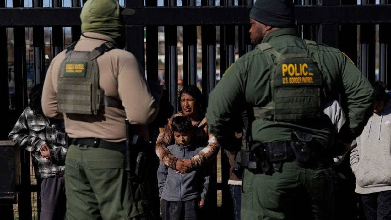 U.S. Border Patrol agents guard migrants that crossed into Shelby Park as they wait to be picked up for processing on February 4, 2024 in Eagle Pass, Texas.