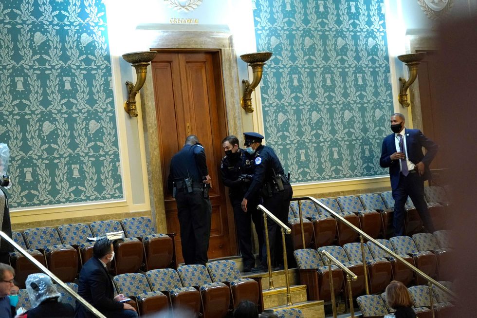 U.S. Capitol Police draw their guns as protesters attempt to enter the House Chamber during a joint session of Congress on January 06, 2021 in Washington, DC. Congress held a joint session today to ratify President-elect Joe Biden